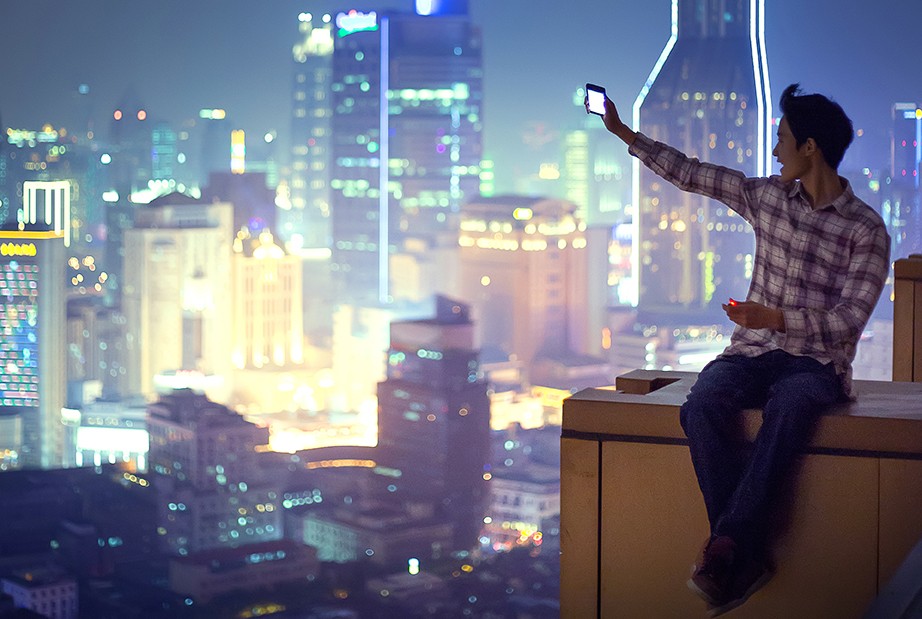 A young man sits on top of the world - calling home